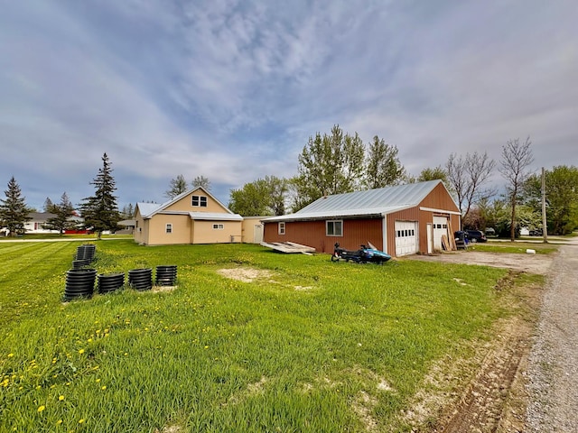 113 6th Ave SE, Baudette, MN 56623 - view of side of home with a yard, dirt driveway, a garage, and metal roof