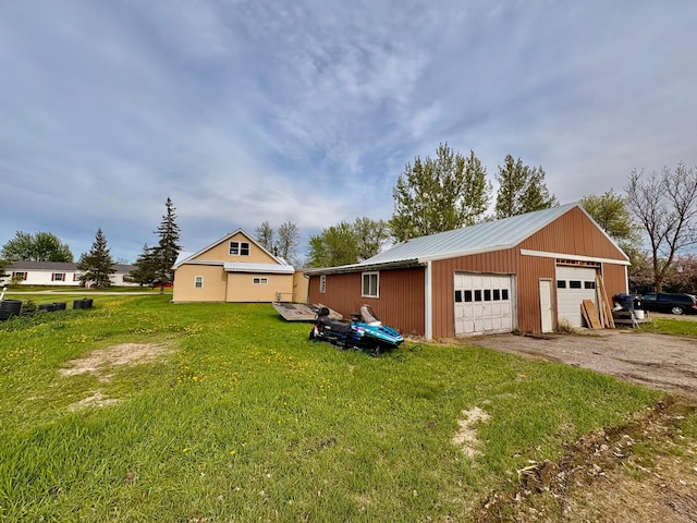113 6th Ave SE, Baudette, MN 56623 - view of side of home with a garage, a lawn, metal roof, and an outdoor structure