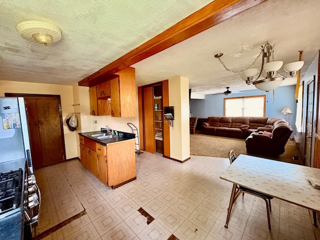 113 6th Ave SE, Baudette, MN 56623 - kitchen featuring a ceiling fan, a textured ceiling, dark countertops, brown cabinetry, and a sink