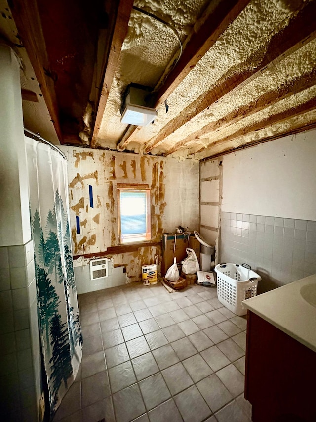 113 6th Ave SE, Baudette, MN 56623 - full bath with tile patterned flooring, tile walls, wainscoting, curtained shower, and a wall mounted air conditioner