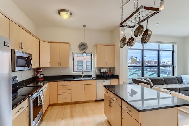 270 4th St E Unit 402, Saint Paul, MN 55101 - kitchen with stainless steel appliances, a sink, light brown cabinets, light wood-style flooring, and a kitchen island