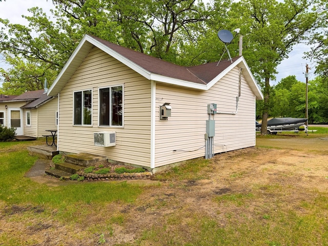 27621 83 Unit 2, Battle Lake, MN 56515 - view of property exterior featuring a wall mounted air conditioner, a shingled roof, and a yard