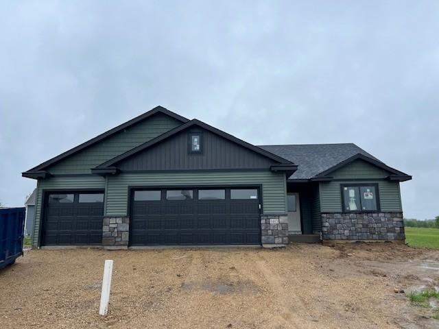 1483 Grand View Ln SE, Mazeppa, MN 55956 - craftsman-style home featuring stone siding, an attached garage, and dirt driveway