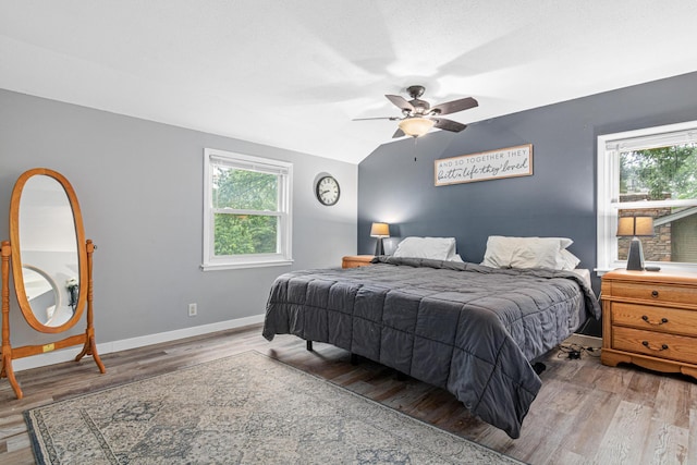 7912 Hillside Trl S, Cottage Grove, MN 55016 - bedroom featuring multiple windows, wood finished floors, baseboards, vaulted ceiling, and ceiling fan