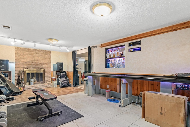 7912 Hillside Trl S, Cottage Grove, MN 55016 - workout room with a textured ceiling, tile patterned flooring, and a fireplace