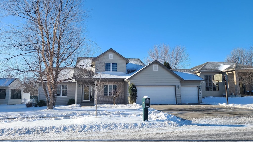 traditional home with a garage, driveway, and brick siding