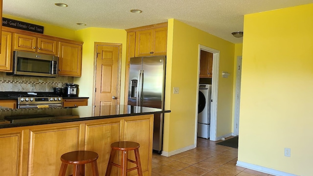 2714 Colleen St NE, Rochester, MN 55906 - kitchen with appliances with stainless steel finishes, dark countertops, light tile patterned floors, tasteful backsplash, and recessed lighting