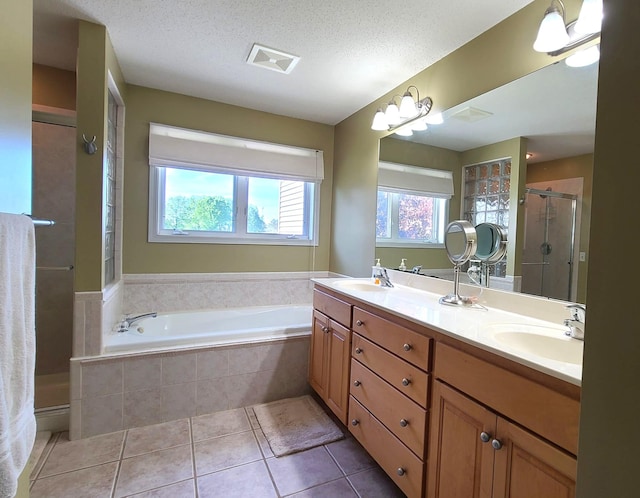 2714 Colleen St NE, Rochester, MN 55906 - full bathroom with a shower stall, tile patterned flooring, double vanity, a bath, and a textured ceiling