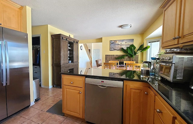 2714 Colleen St NE, Rochester, MN 55906 - kitchen featuring dishwasher, freestanding refrigerator, dark countertops, a peninsula, and a textured ceiling