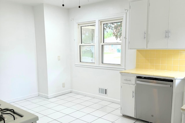 kitchen featuring dishwasher, tile countertops, decorative backsplash, and baseboards