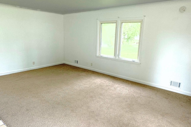 empty room with carpet, baseboards, and a smoke detector