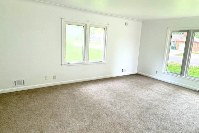 spare room featuring carpet floors and baseboards