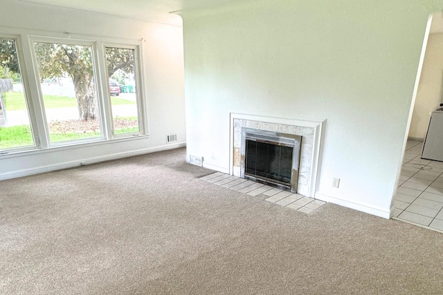 unfurnished living room with carpet flooring, a premium fireplace, and baseboards