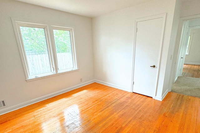 spare room featuring light wood-style floors and baseboards