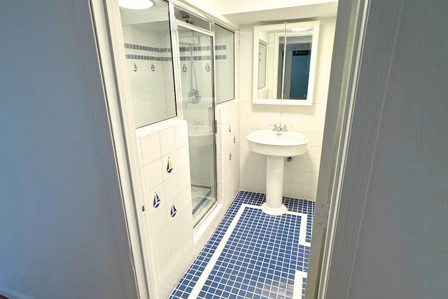 bathroom featuring tile walls, tile patterned flooring, and a shower stall