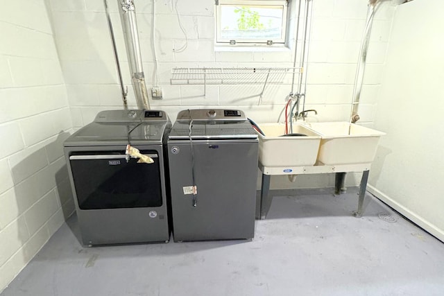 washroom with independent washer and dryer and concrete block wall