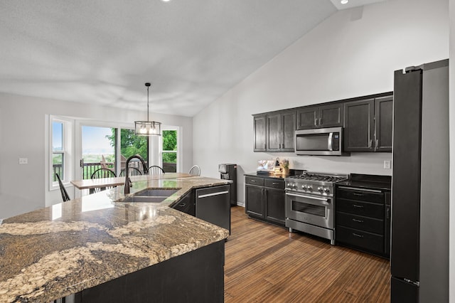 4756 121st Ave NE, Blaine, MN 55449 - kitchen with appliances with stainless steel finishes, a sink, dark wood-style flooring, dark stone countertops, and a large island