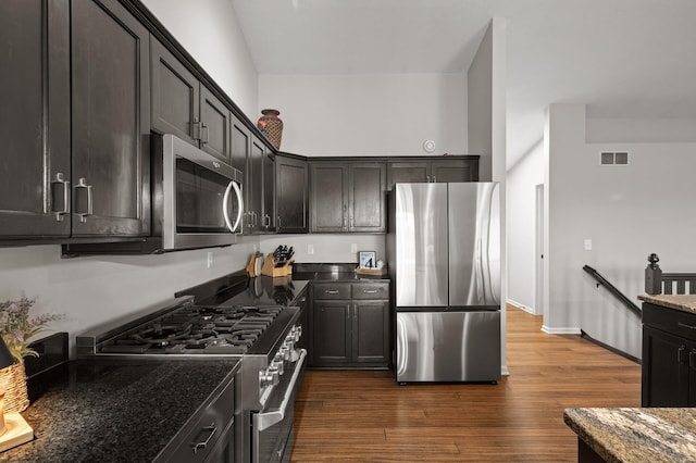 4756 121st Ave NE, Blaine, MN 55449 - kitchen featuring appliances with stainless steel finishes, dark stone counters, dark wood-style floors, and baseboards