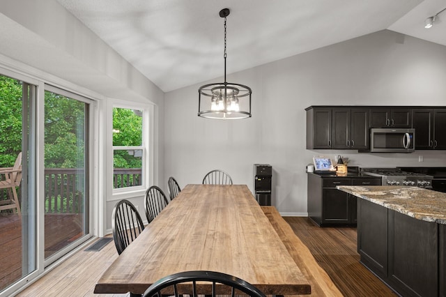 4756 121st Ave NE, Blaine, MN 55449 - dining room with lofted ceiling, wood finished floors, and a chandelier