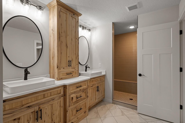 4756 121st Ave NE, Blaine, MN 55449 - bathroom with double vanity, a stall shower, a textured ceiling, marble look tile flooring, and recessed lighting