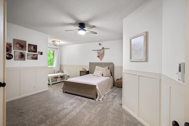 4756 121st Ave NE, Blaine, MN 55449 - carpeted bedroom with a wainscoted wall, a textured ceiling, a decorative wall, and ceiling fan