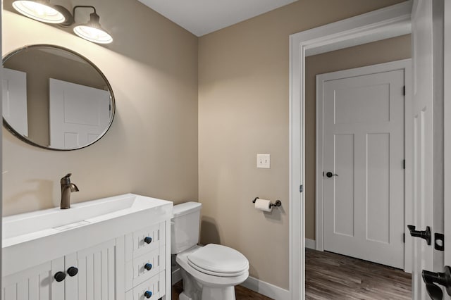 4756 121st Ave NE, Blaine, MN 55449 - bathroom with wood finished floors, toilet, vanity, and baseboards