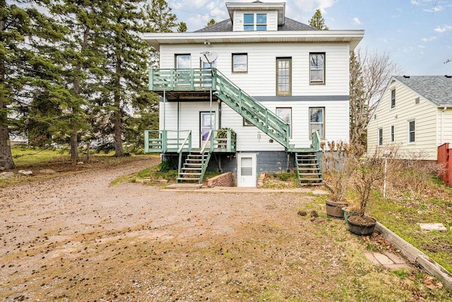 back of house featuring stairway and a deck