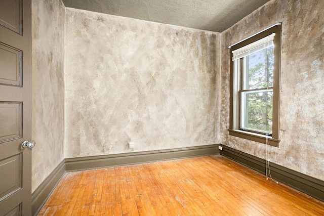 unfurnished room featuring light wood finished floors and baseboards
