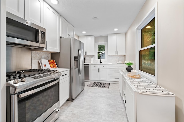37 Harrison Ave S, Hopkins, MN 55343 - kitchen with appliances with stainless steel finishes, tasteful backsplash, light countertops, white cabinets, and recessed lighting