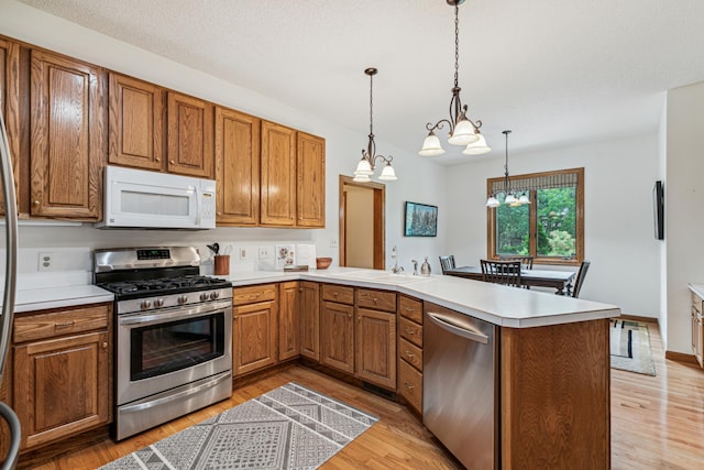 10791 3rd Street Pl N, Lake Elmo, MN 55042 - kitchen with stainless steel appliances, a sink, a peninsula, and brown cabinets