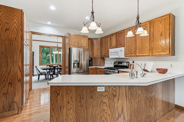 10791 3rd Street Pl N, Lake Elmo, MN 55042 - kitchen with stainless steel appliances, a chandelier, brown cabinetry, light wood-type flooring, and recessed lighting