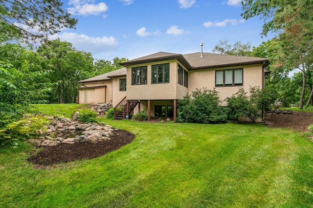 10791 3rd Street Pl N, Lake Elmo, MN 55042 - rear view of house featuring a yard, stairway, a garage, and stucco siding