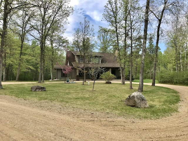 view of front facade featuring a chimney, a front lawn, and roof with shingles