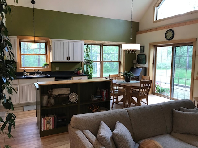 living room featuring high vaulted ceiling and light wood-style floors