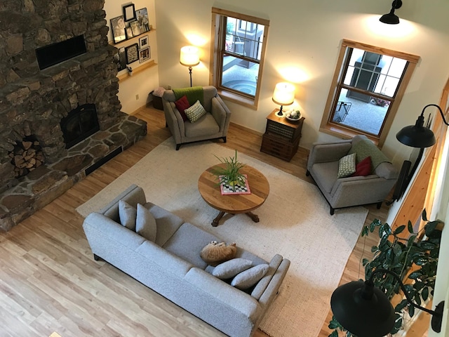 living area with wood finished floors and a stone fireplace