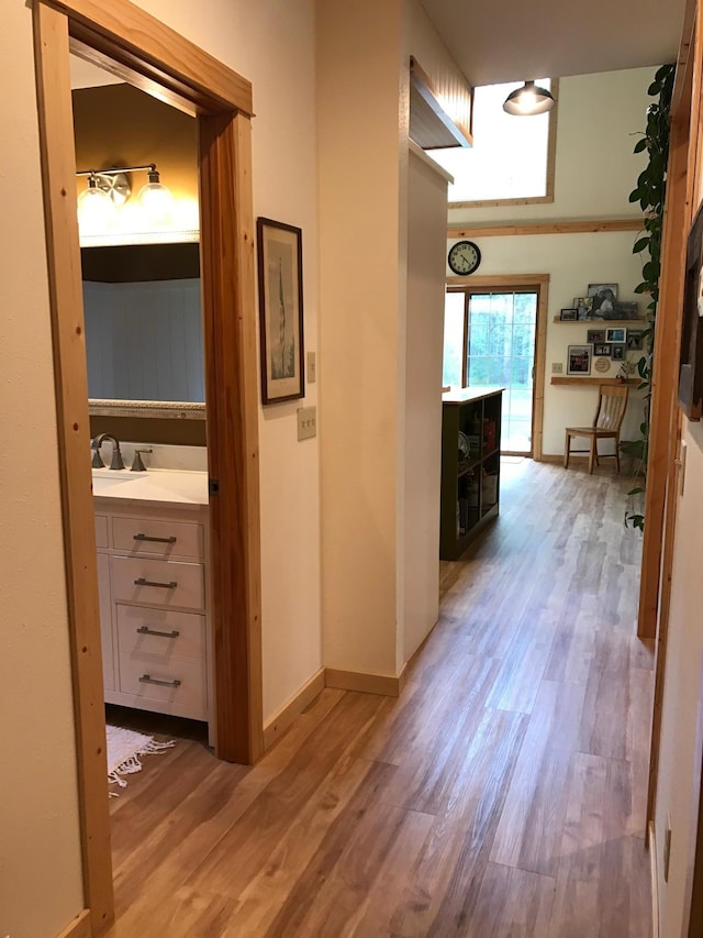 hall featuring light wood finished floors and baseboards