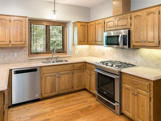 17768 Keystone Ave, Lakeville, MN 55044 - kitchen with stainless steel appliances, a sink, light wood-type flooring, hanging light fixtures, and decorative backsplash