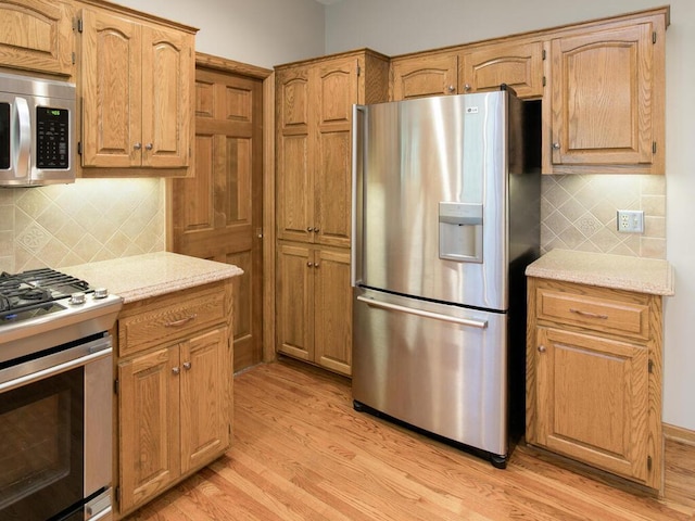 17768 Keystone Ave, Lakeville, MN 55044 - kitchen featuring stainless steel appliances, light wood-style floors, tasteful backsplash, and light stone countertops