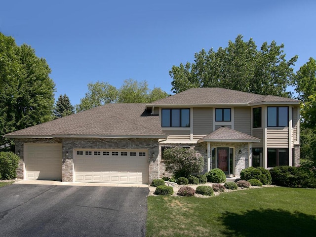 17768 Keystone Ave, Lakeville, MN 55044 - view of front facade with a garage, asphalt driveway, a front lawn, brick siding, and a shingled roof