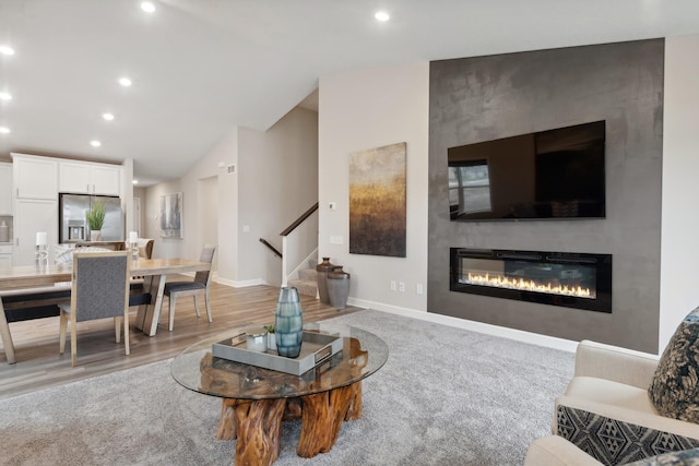 6749 168th Ln N, Ramsey, MN 55303 - living area with a glass covered fireplace, vaulted ceiling, stairs, recessed lighting, and baseboards