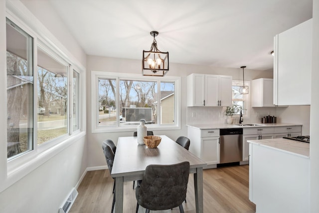 761 Labore Rd, Little Canada, MN 55117 - kitchen featuring dishwasher, a sink, a chandelier, white cabinets, and light wood-type flooring