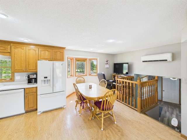 31528 63rd St, Royalton, MN 56373 - kitchen featuring white appliances, a wall mounted AC, light wood-type flooring, a textured ceiling, and plenty of natural light