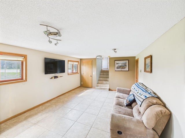 31528 63rd St, Royalton, MN 56373 - living area with stairs, healthy amount of natural light, light tile patterned floors, a textured ceiling, and baseboards