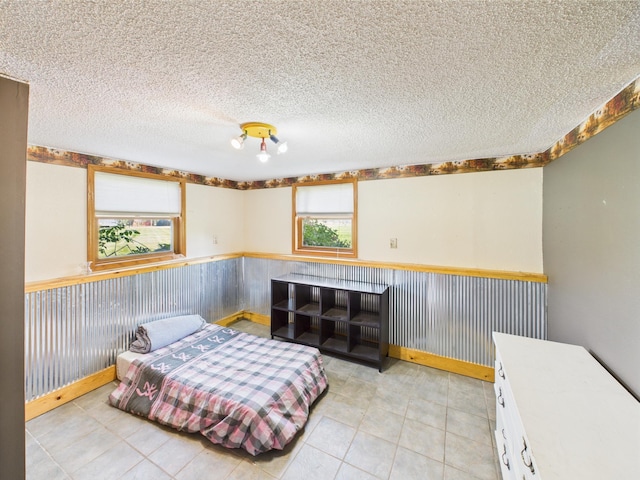 31528 63rd St, Royalton, MN 56373 - bedroom featuring a wainscoted wall, a textured ceiling, and light tile patterned flooring