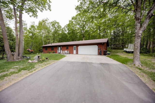 30202 Shady Ln, Detroit Lakes, MN 56501 - view of front of house with asphalt driveway, a garage, a front lawn, and view of wooded area