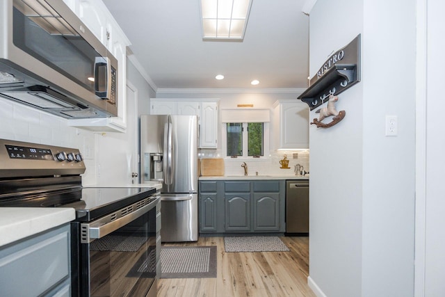 30202 Shady Ln, Detroit Lakes, MN 56501 - kitchen with stainless steel appliances, a sink, backsplash, light countertops, and crown molding