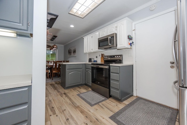 30202 Shady Ln, Detroit Lakes, MN 56501 - kitchen with appliances with stainless steel finishes, crown molding, light wood-style flooring, gray cabinetry, and white cabinets