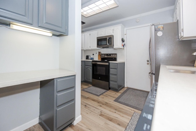 30202 Shady Ln, Detroit Lakes, MN 56501 - kitchen with appliances with stainless steel finishes, light wood-style flooring, crown molding, light countertops, and white cabinets