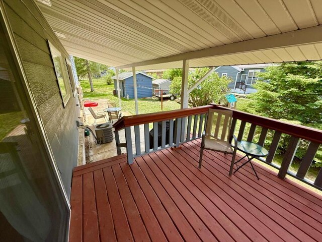 725 8th St NE, Staples, MN 56479 - wooden deck with an outbuilding, a shed, and central AC unit