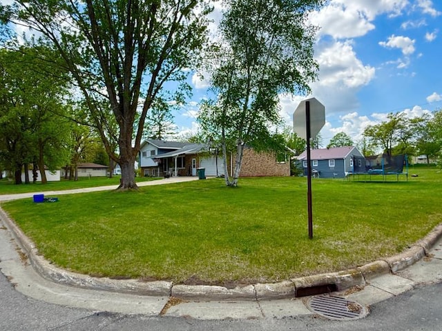 725 8th St NE, Staples, MN 56479 - view of front facade featuring a trampoline, a front lawn, and a garage